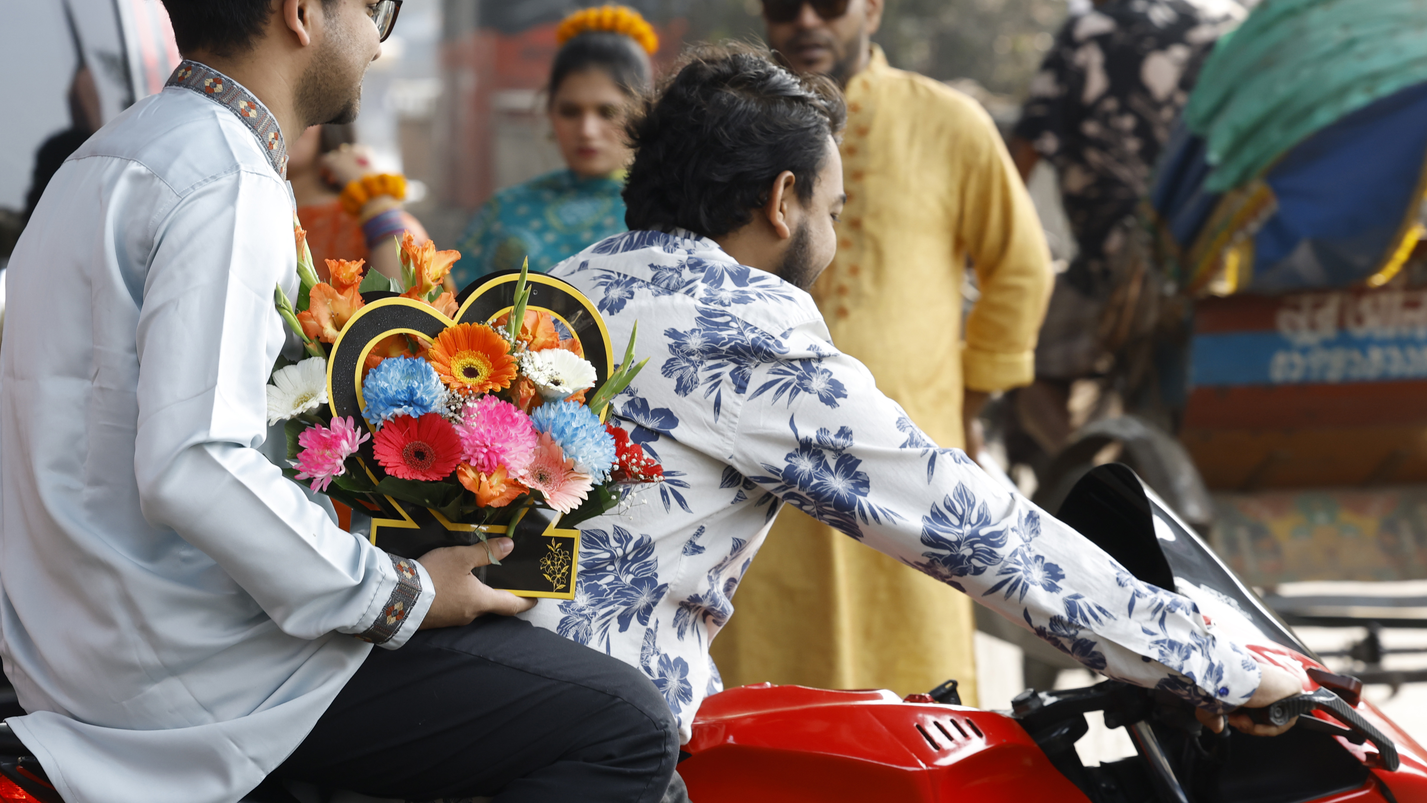 প্রিয়জনকে উপহার দিতে বাসায় ফুল নিয়ে যাচ্ছেন এক তরুণ