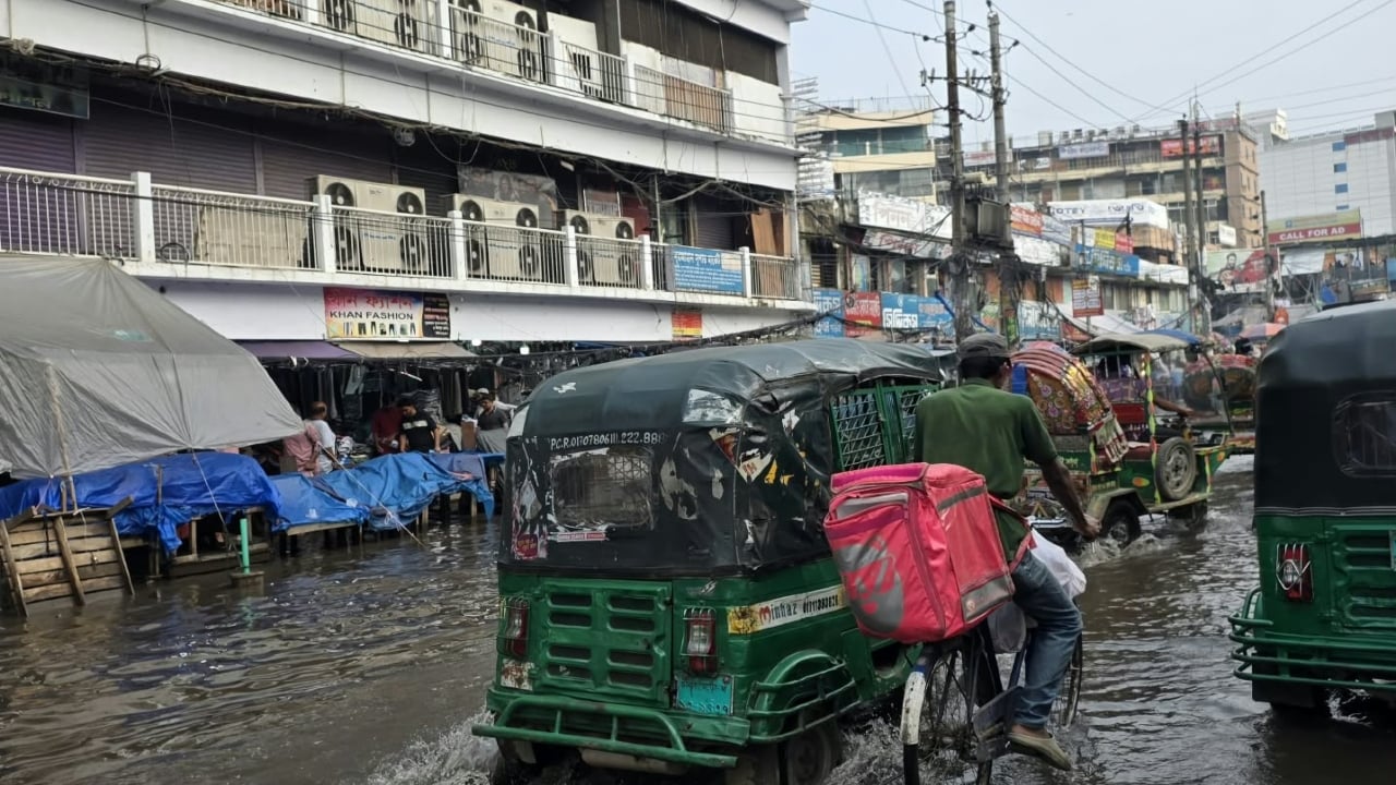 জীবিকার তাগিদে জলমগ্ন সড়কে ছুটে চলছেন ফুড পান্ডার এক কর্মী