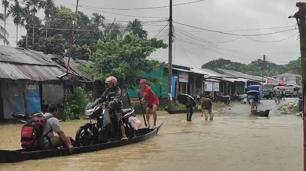 দীঘিনালা–সাজেক সড়কের কবাখালি এলাকায় পানি ওঠায় নৌকা নিয়ে পারাপার করছে অনেকে