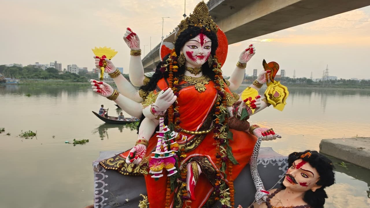 বিসর্জনের জন্য নদীর পানিতে নামানো হচ্ছে দেবী দুর্গার প্রতিমা। বিদায়ের মুহূর্তে নদীর তীরে ভিড় করেছেন ভক্তরা। ছবি: সিজেডএন টোয়েন্টিফোর