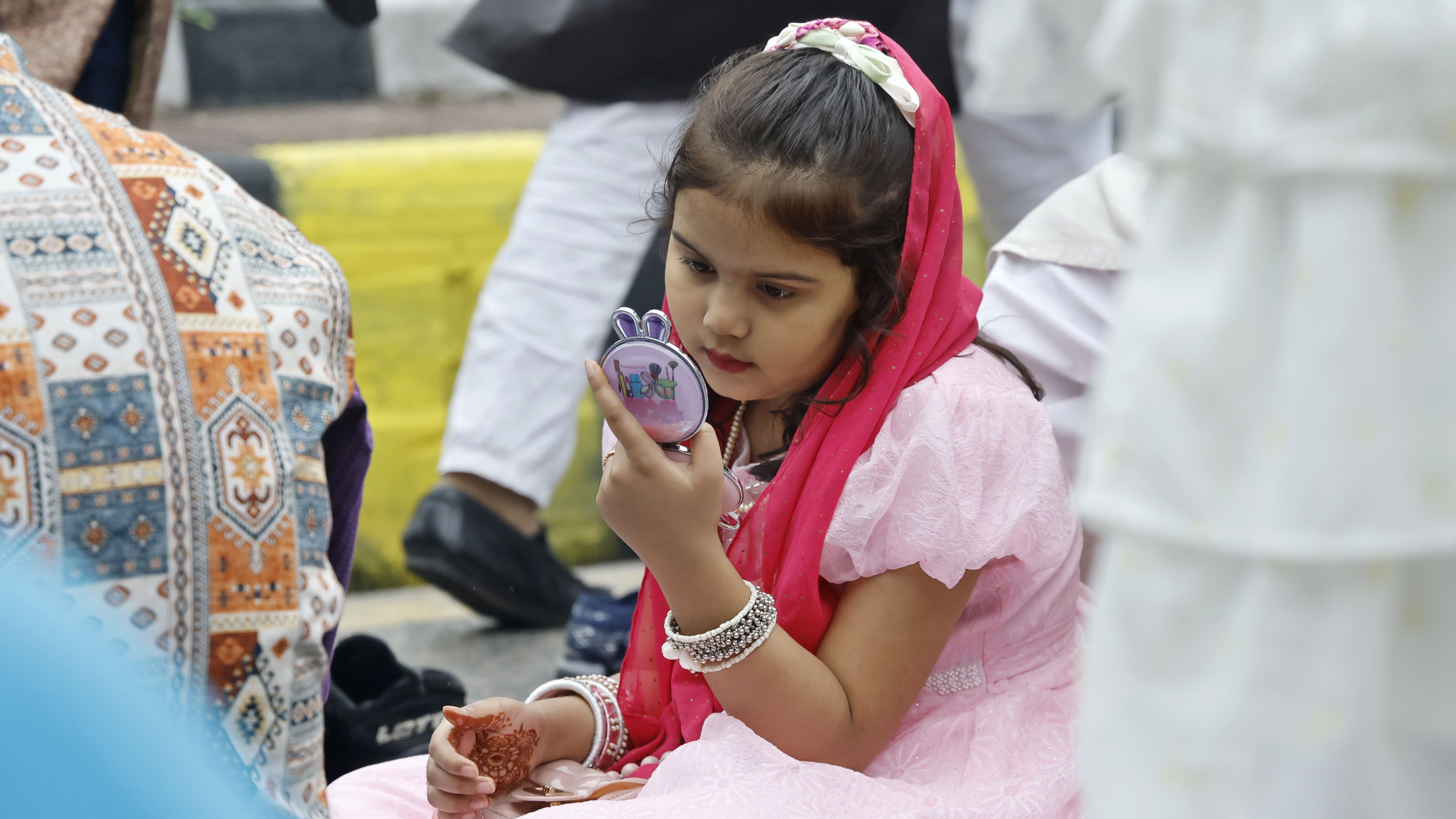 বাবার সঙ্গে নামাজ শেষে নিজেকে সাজিয়ে নিতে ব্যস্ত এক শিশু