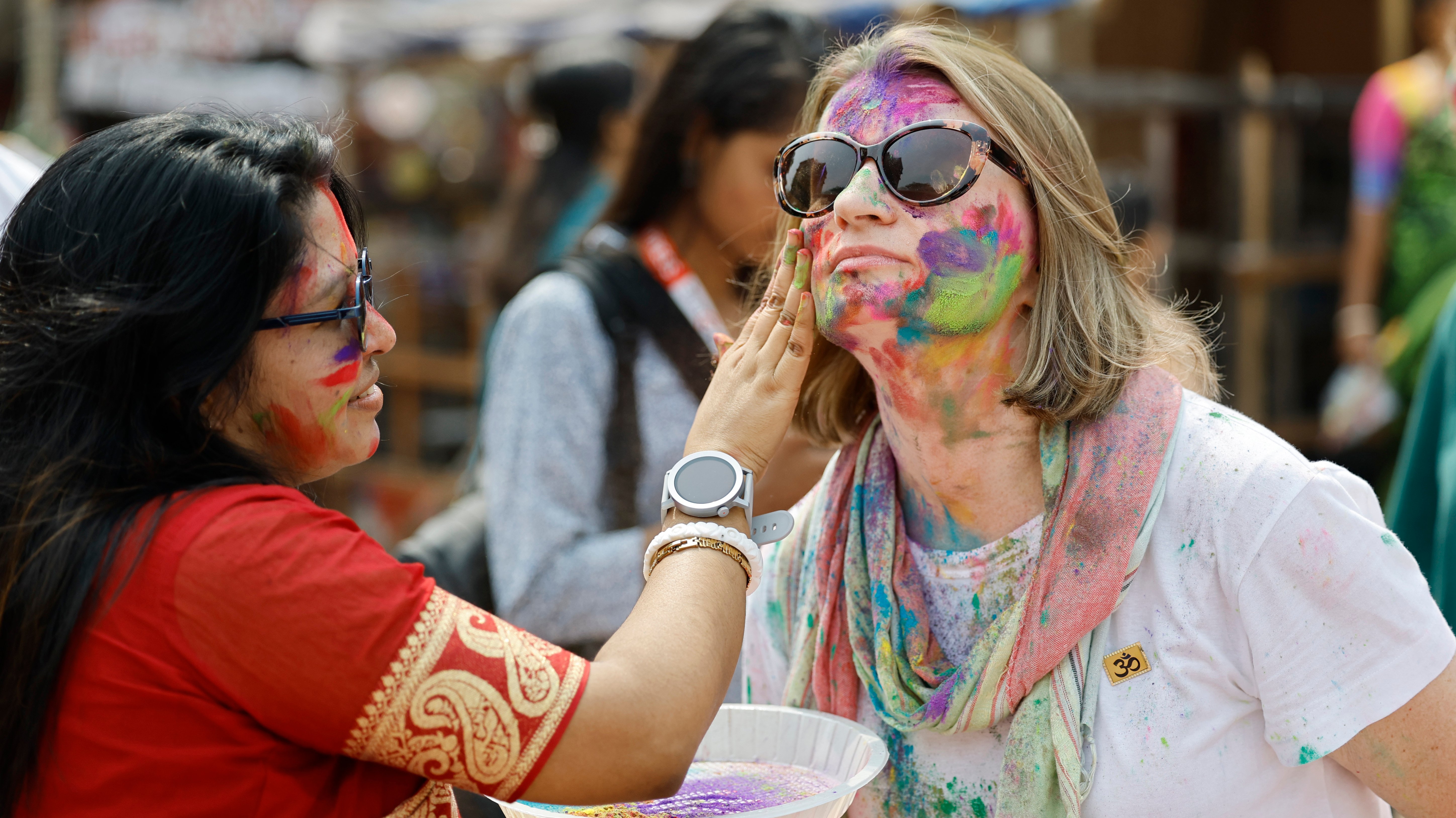 বিদেশি পর্যটকরা দোল উৎসবে অংশ নিলে আবির মাখিয়ে দেন এক নারী