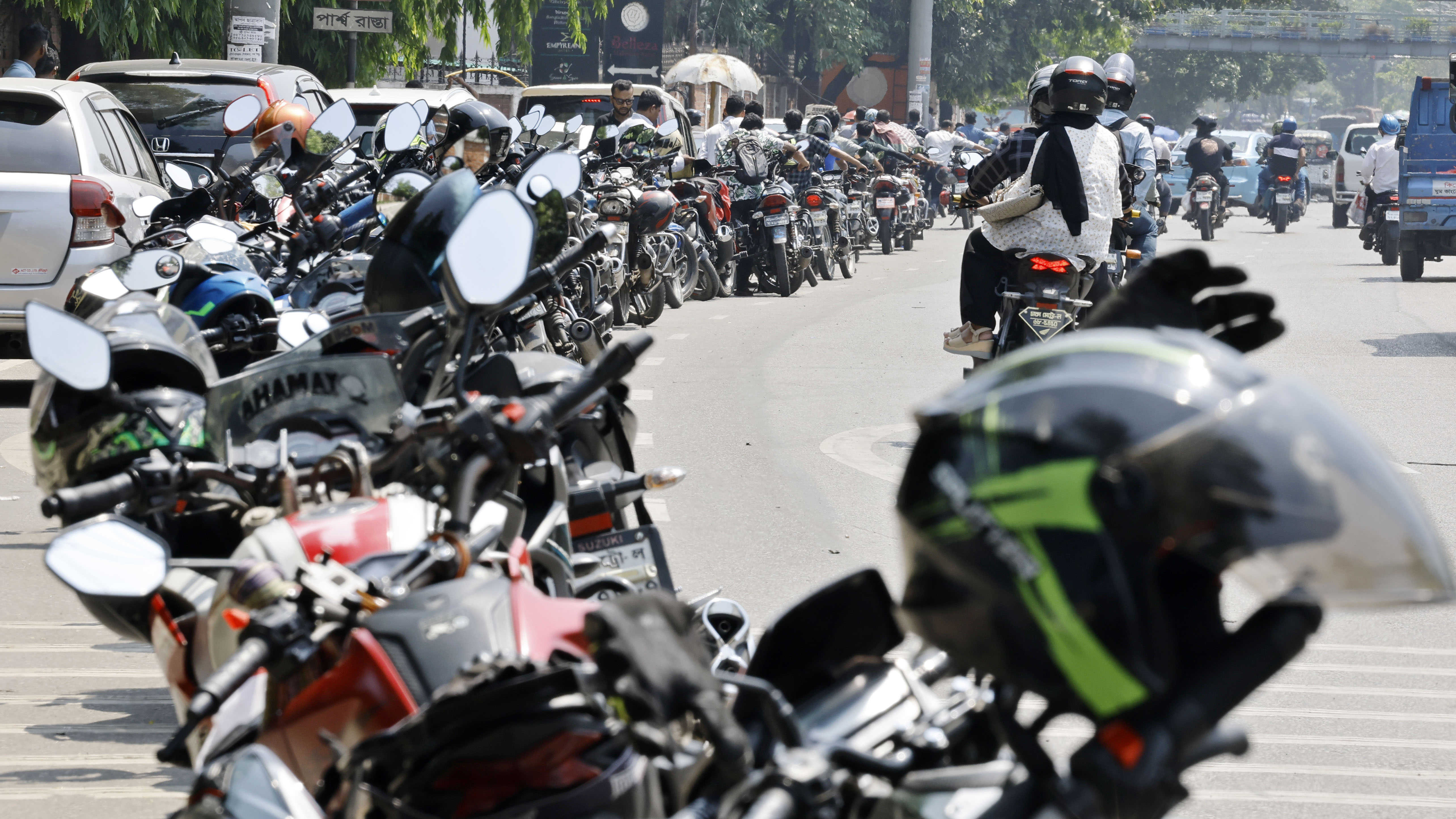 তপ্ত গরমে রাস্তায় দাঁড়ানোর উপায় নেই। তাই মোটরসাইকেল রেখে সব চালক দাঁড়িয়েছেন ছায়ায়