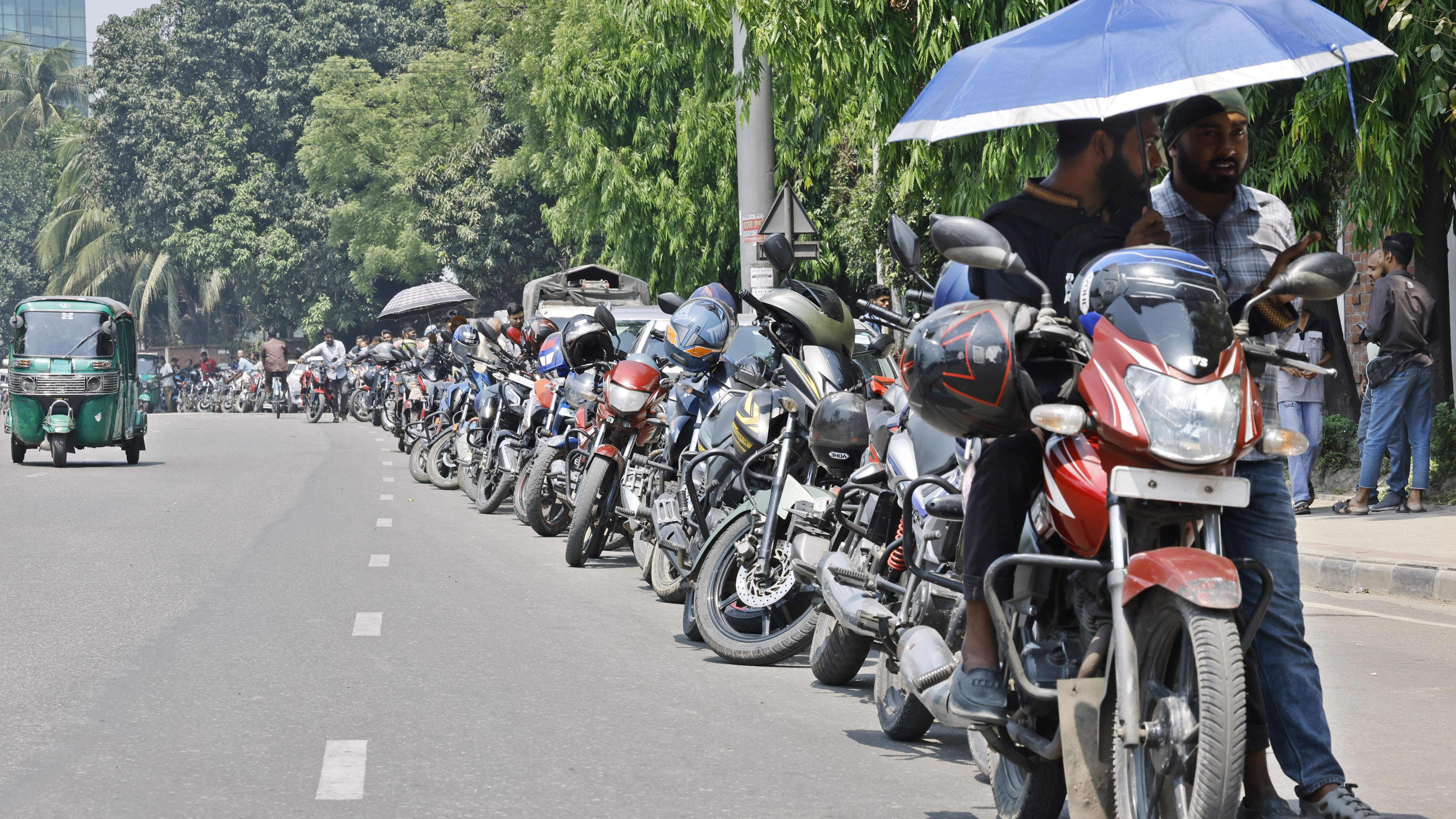 অনেকেই ছাতা মাথায় দিয়ে অপেক্ষা করছেন