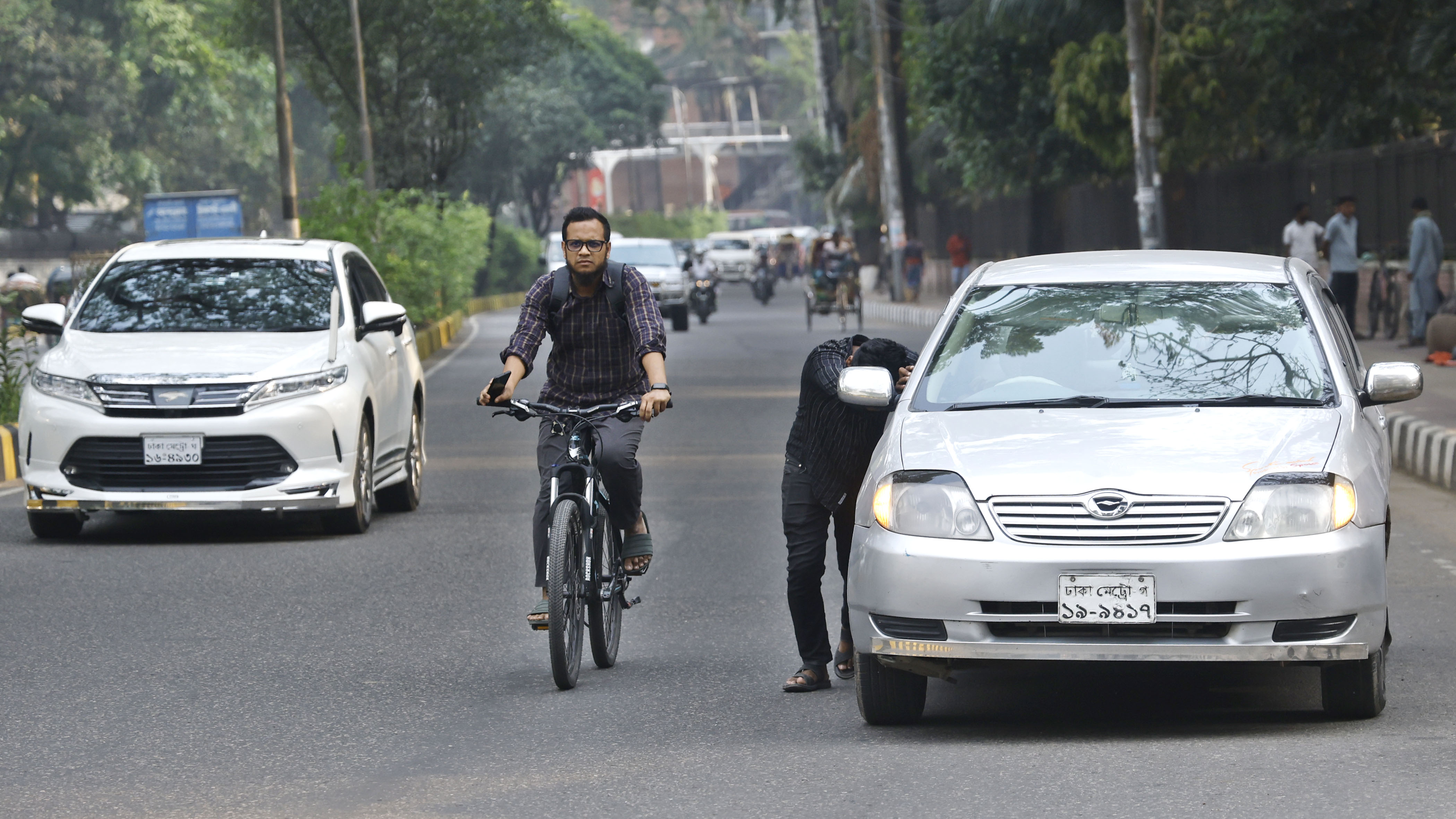 জ্বালানি তেল শেষ হয়ে যাওয়ায় ঠেলে পাম্পে গাড়ি নিয়ে যাচ্ছেন এক চালক