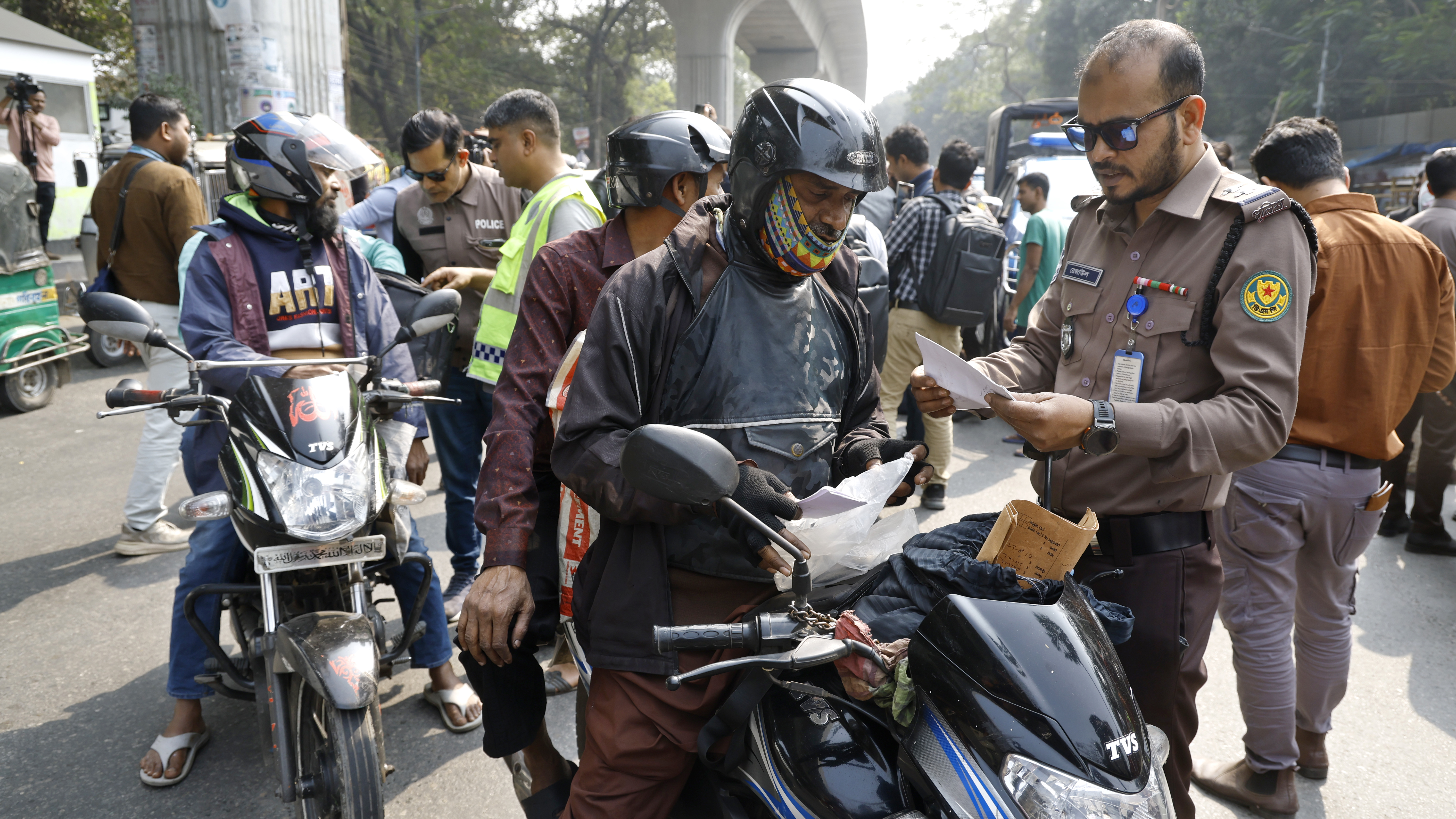 নিরাপত্তার অংশ হিসেবে মোটরসাইকেলের কাগজপত্র পরীক্ষা করেন আইনশৃঙ্খলা বাহিনীর সদস্যরা
