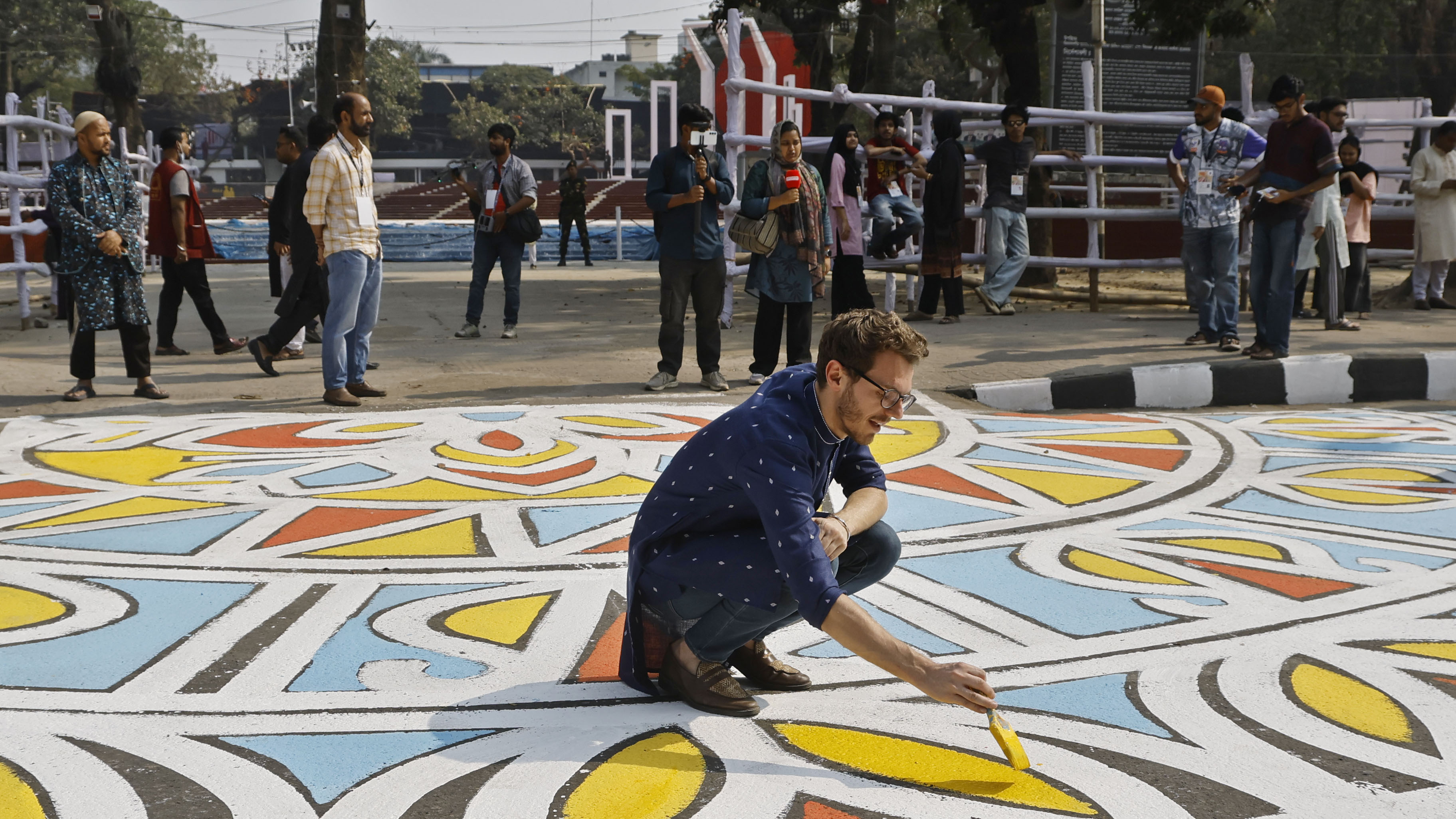 এক বিদেশি পর্যটককে দেখা গেছে আল্পনা করতে