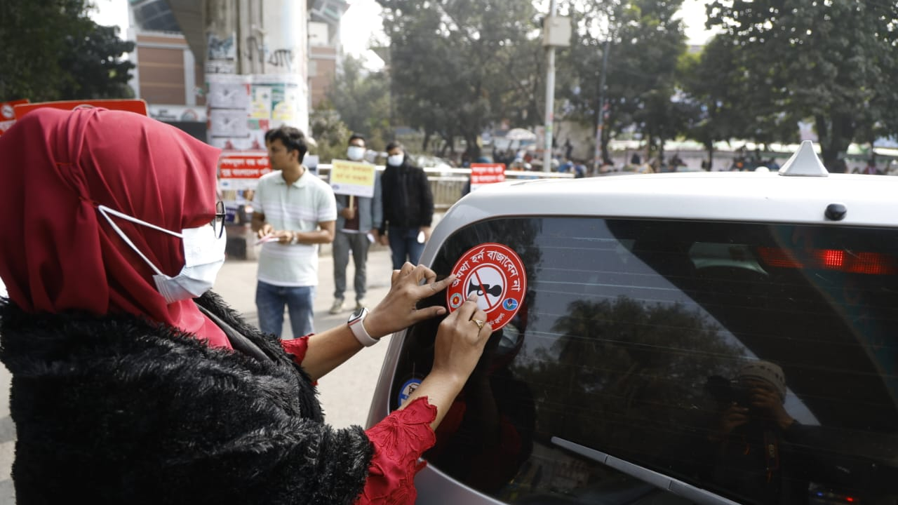 শব্দদূষণ রোধে ঢাকা বিশ্ববিদ্যালয়ের রাজু ভাস্কর্যের সামনে যানবাহনে স্টিকার সাঁটানো হয়।