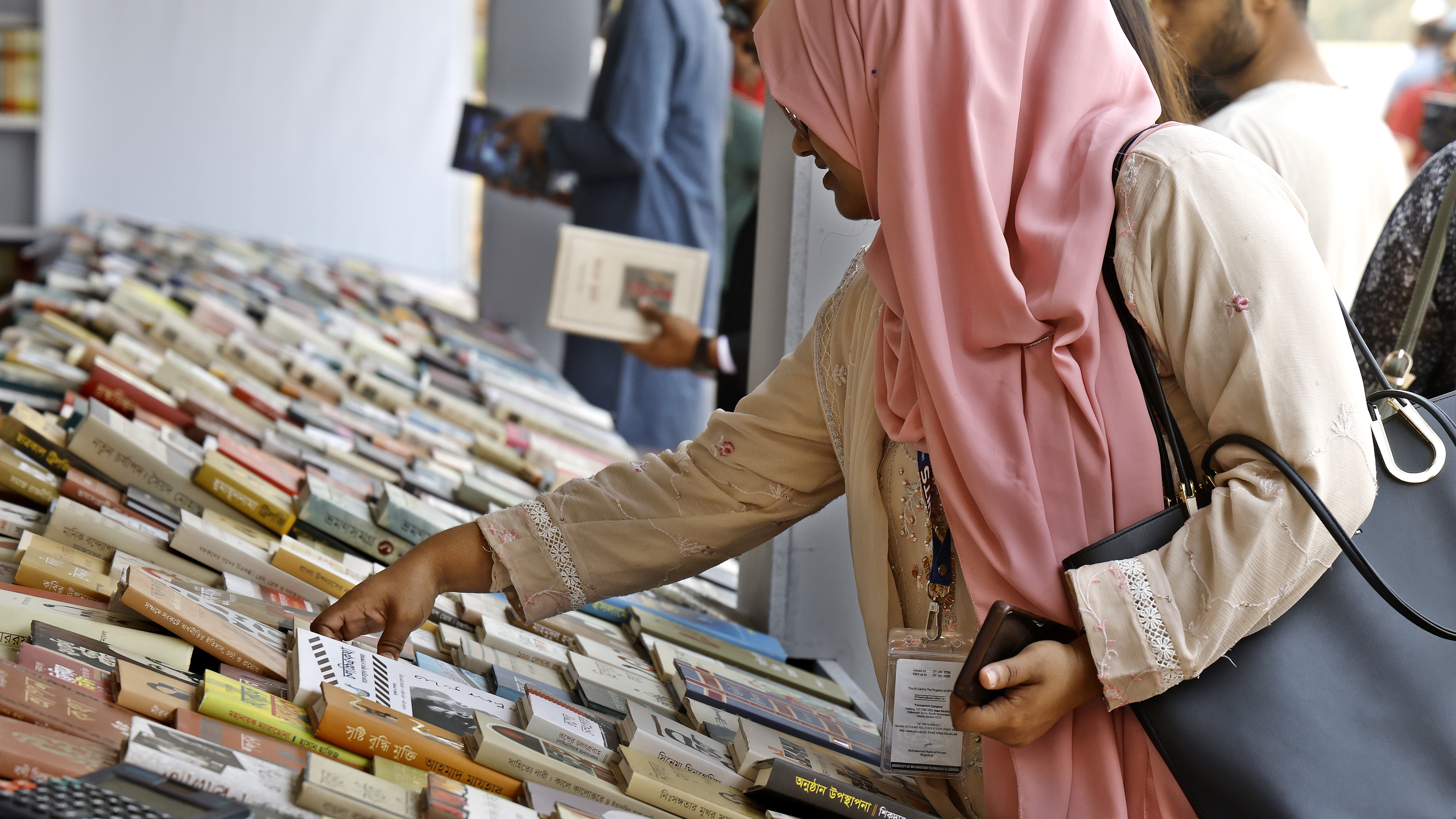 শত শত বইয়ের মাঝে পছন্দের বই খুঁজছেন একজন