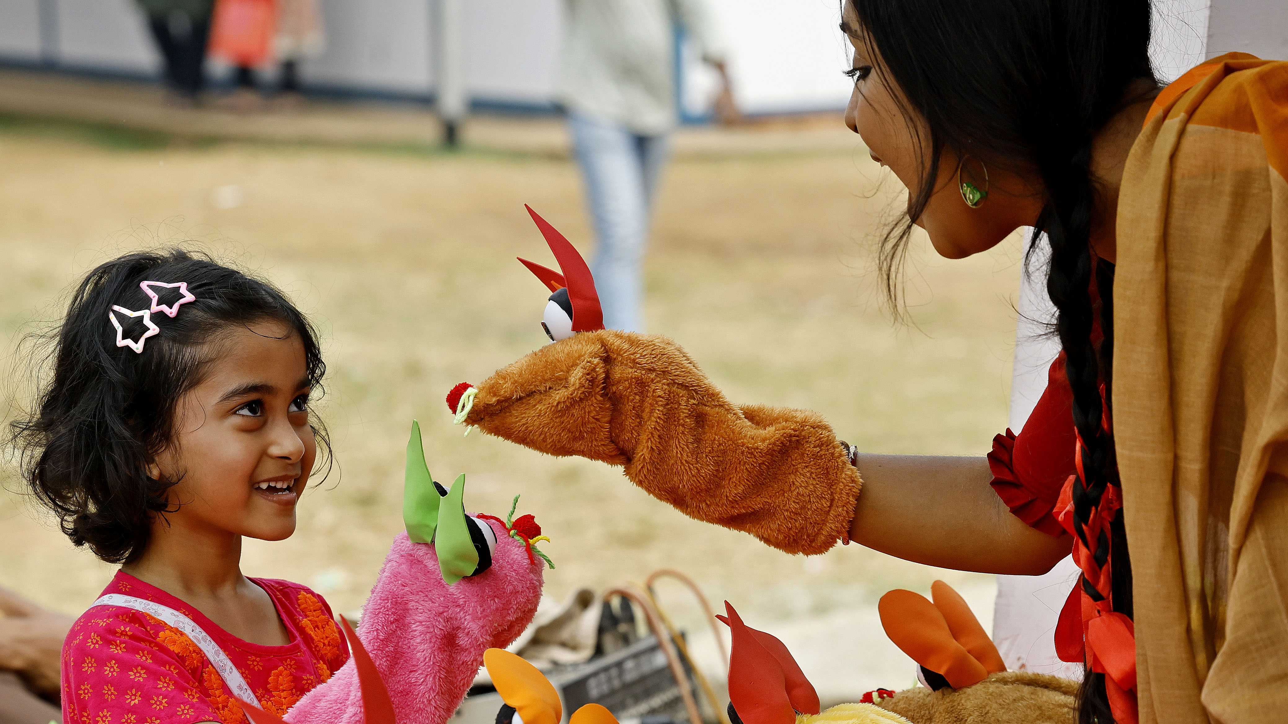 আয়োজকের সঙ্গে মোজার পাপেট দিয়ে খেলায় মেতে উঠেছে এক শিশু