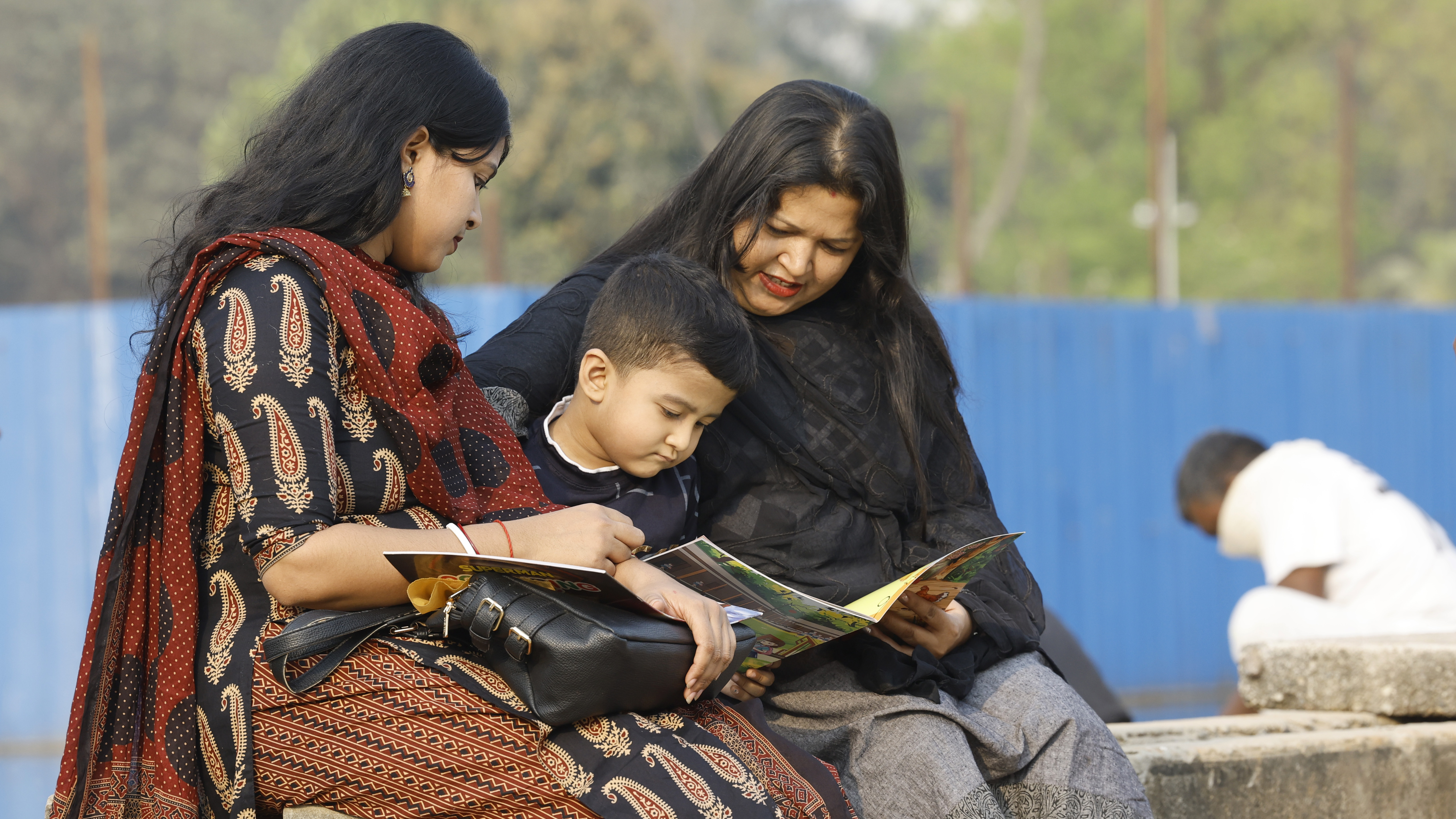 তর সইতে না পেরে মেলা প্রাঙ্গণেই মায়ের সঙ্গে পছন্দের কমিক বই দেখছে এক শিশু