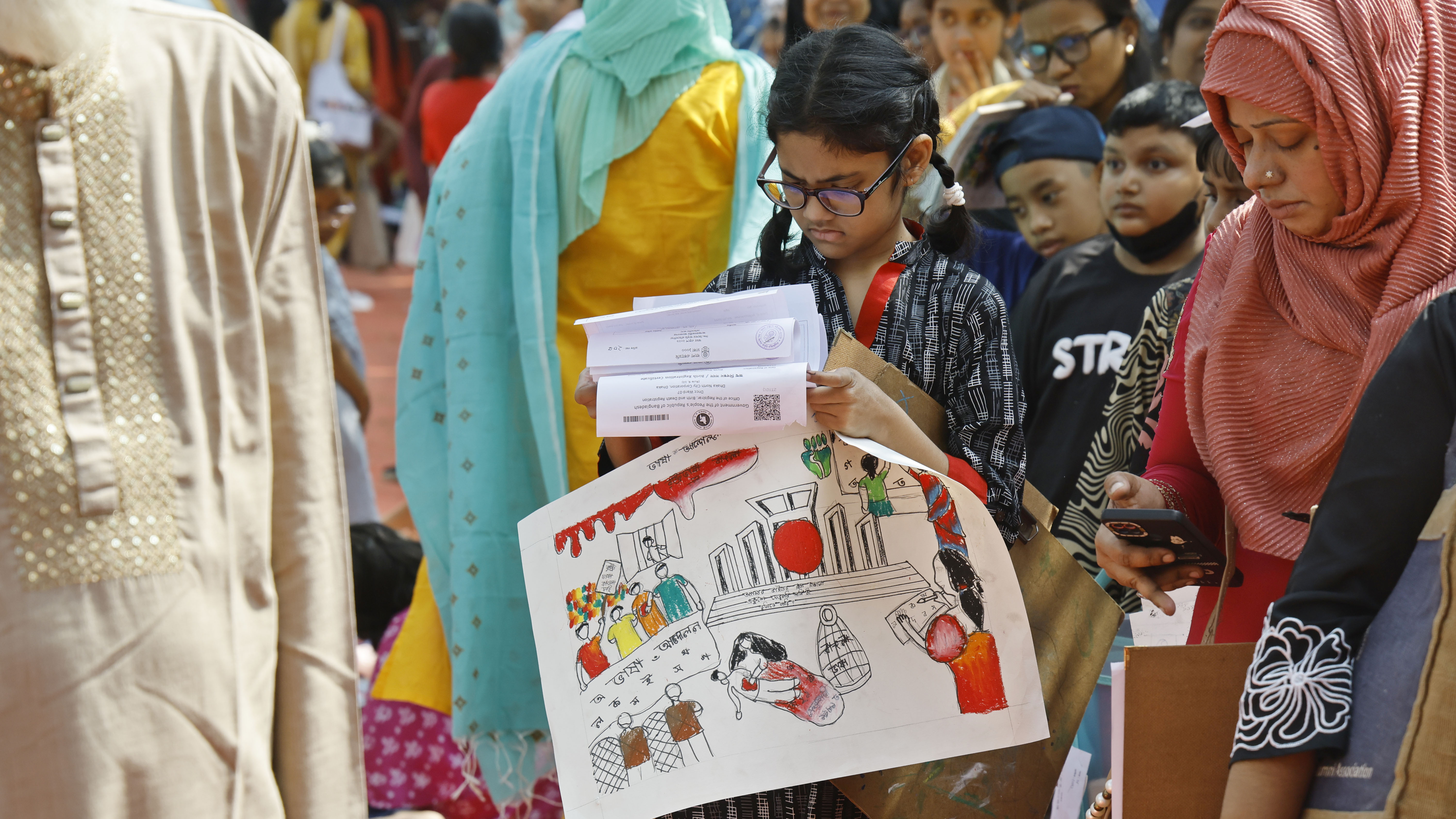 ছবি আঁকা শেষে জমা দিতে লাইনে দাঁড়িয়ে এক শিশু