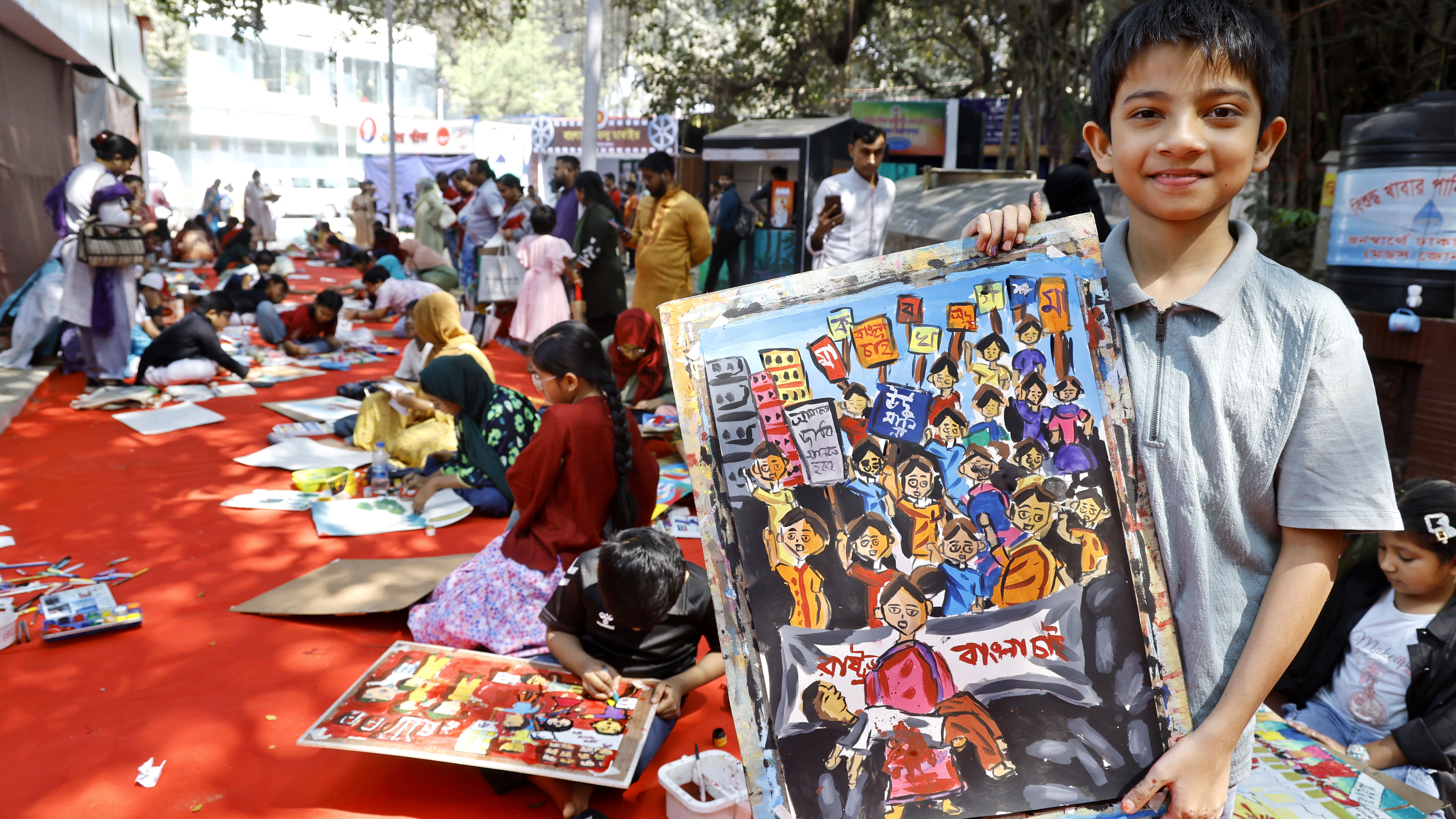 ছবি আঁকা শেষ করে দেখাচ্ছে এক শিশু