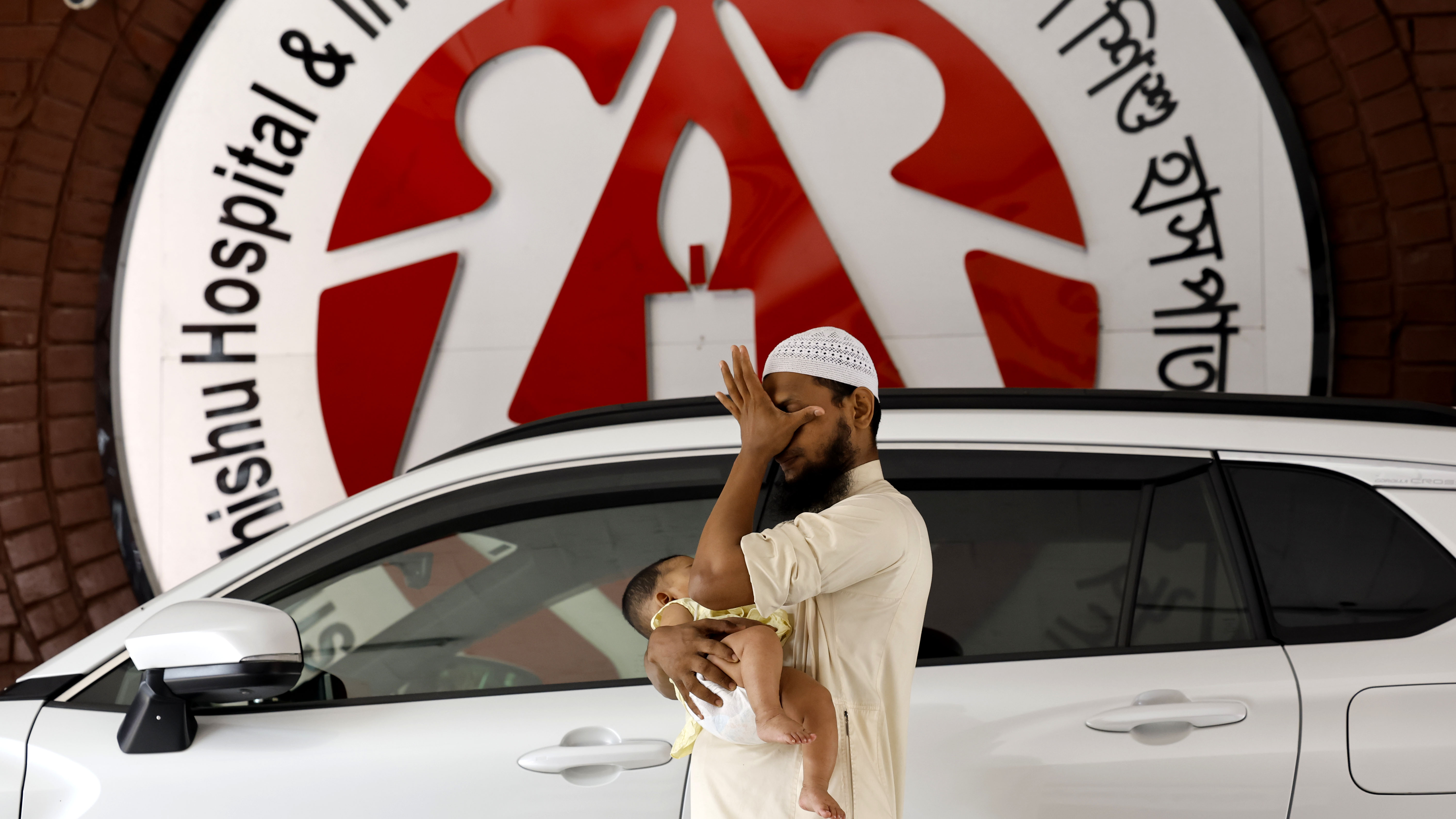 অসুস্থ সন্তানকে নিয়ে হাসপাতালের সামনে চিন্তাগ্রস্থ বাবা