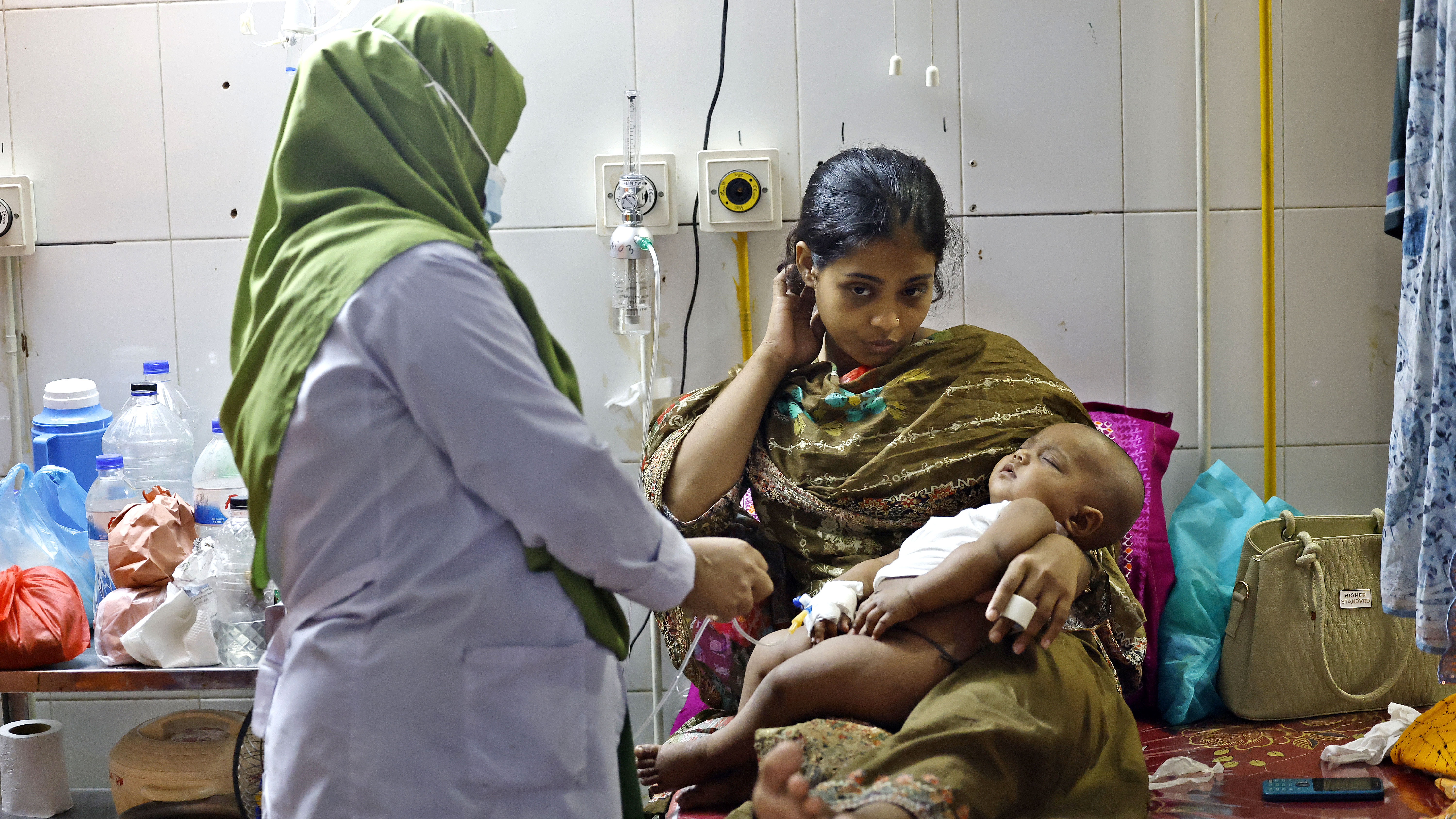 আক্রান্ত শিশুকে চিকিৎসা দিচ্ছেন এক স্বাস্থ্যকর্মী