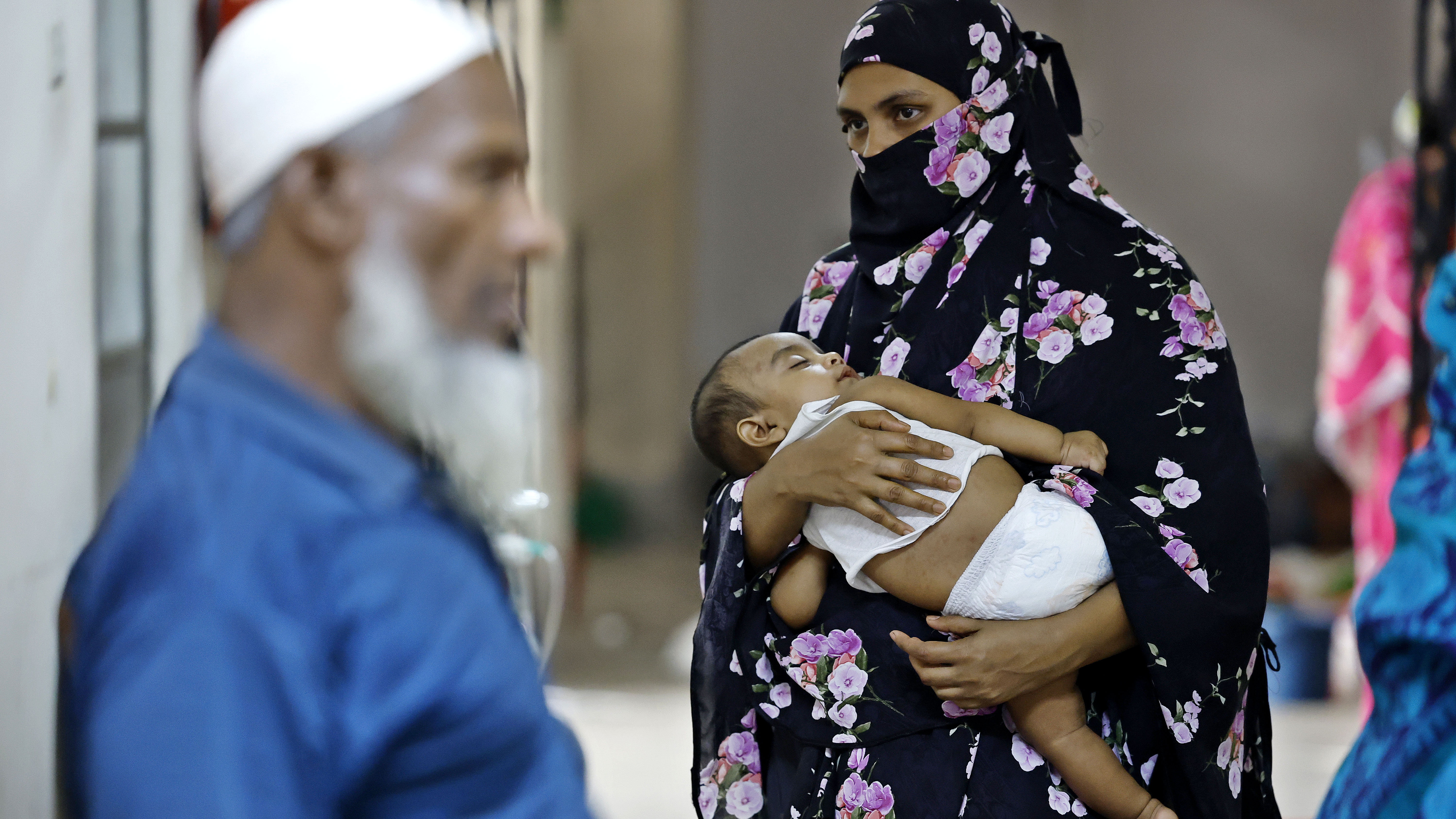 সন্তানকে কোলে নিয়ে স্বস্তি দেওয়ার চেষ্টা করছেন মা