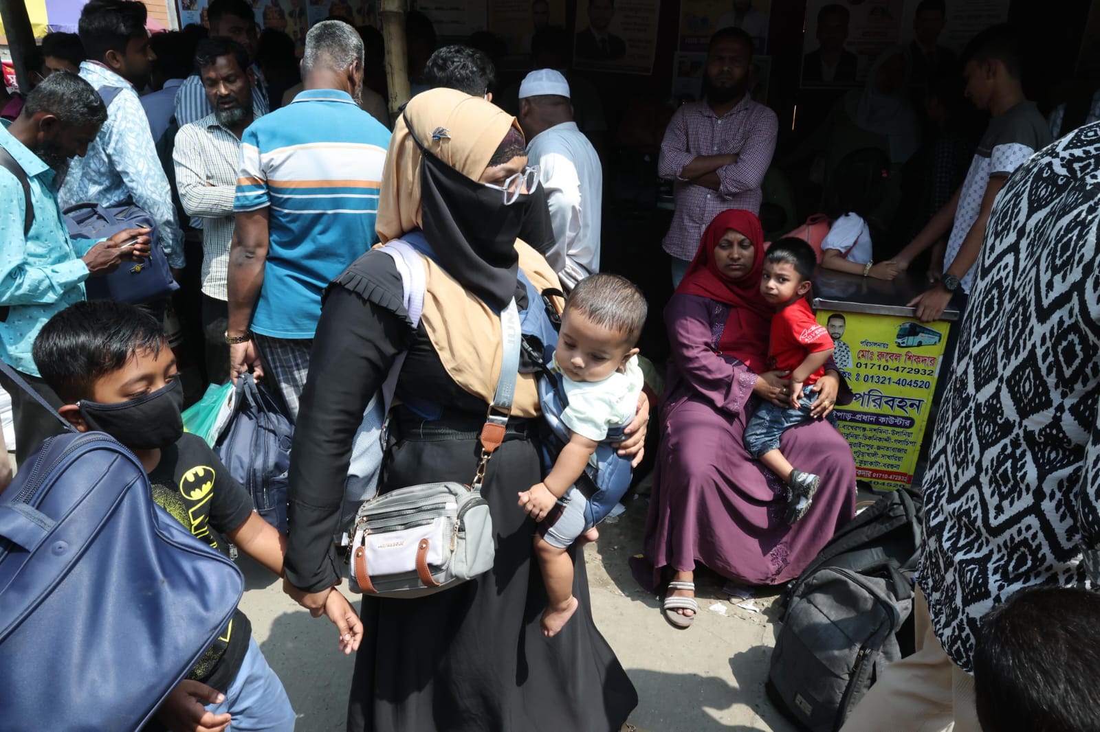 ছোট্ট শিশুকে নিয়ে বাসের জন্য অপেক্ষারত এক মা