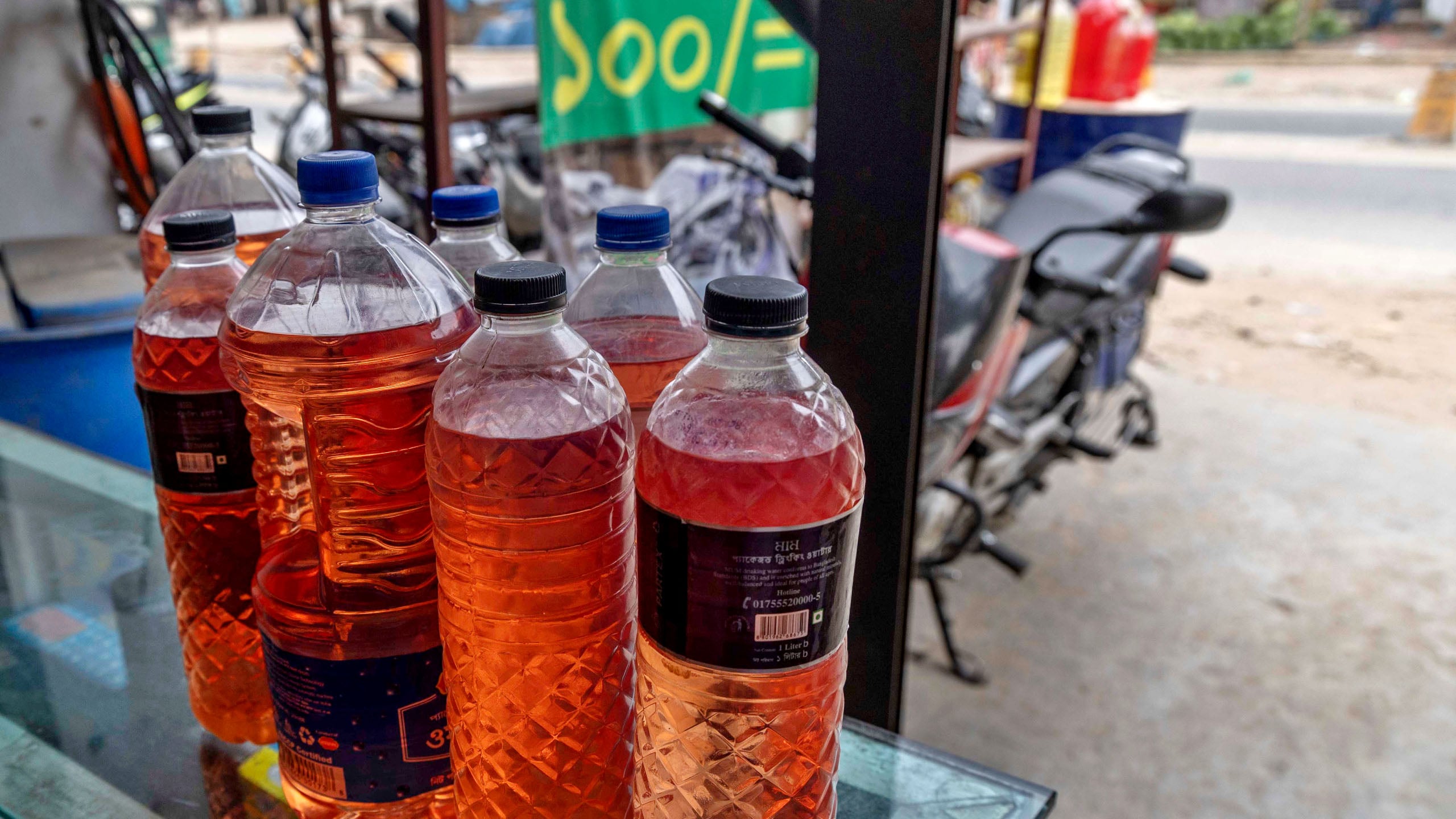 রাজধানীর বসিলা এলাকায় রাস্তার পাশের দোকানে বিক্রি হচ্ছে খোলা অকটেন ও পেট্রোল