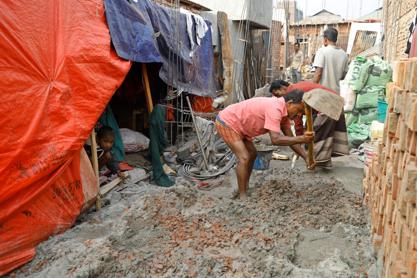 নতুন ঘর তৈরিতে ব্যস্ত বাসিন্দারা। চলছে ইট-বালু দিয়ে ঢালাইয়ের কাজ।