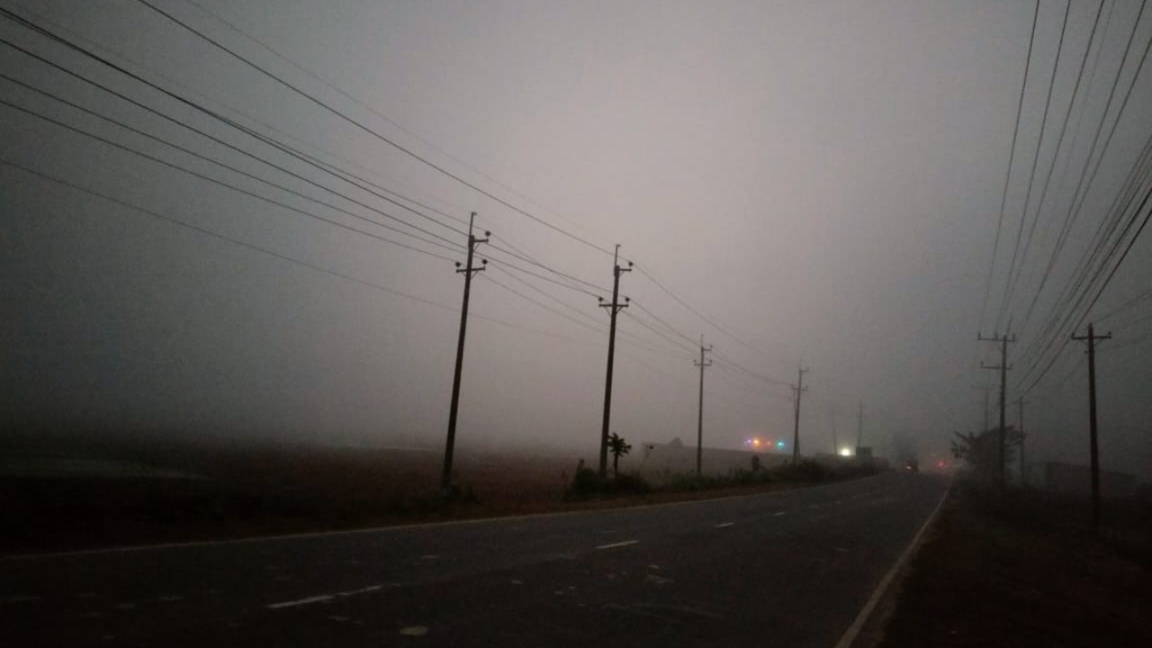 ঘন কুয়াশার চাদরে ঢাকা গ্রামীণ সড়ক– কয়েক হাত দূরের কিছুই দেখা যায় না, প্রকৃতি যেন নিঃশব্দে সবকিছু আড়াল করে রেখেছে।