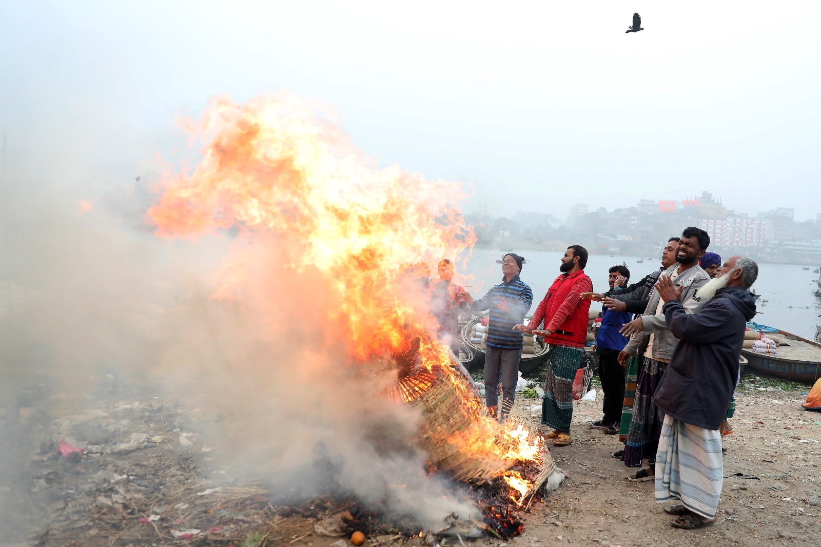 আগুন জ্বালিয়ে শীত নিবারণের চেষ্টা করছেন তারা। সোমবার রাজধানীর চানখারপুল এলাকায় গিয়ে দেখা যায় এমন দৃশ্য।
